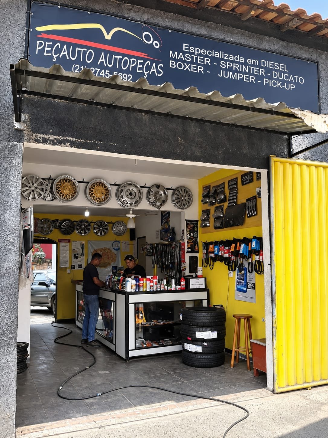 Loja Peçauto em uma fase de crescimento, com fachada escura e interior amarelo